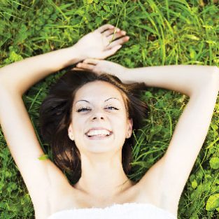 Live-Your-Vitality-woman_lying_in_the-grass_smiling_happy_shutterstock_60130228